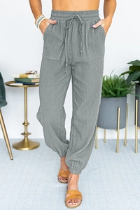 Detailed texture of grey high waist casual joggers featuring square pockets and drawstring