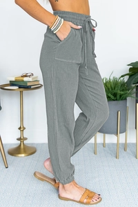 Detailed view of high waisted grey joggers featuring crinkle fabric texture and drawstring