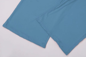 Dettaglio ravvicinato della cucitura a doppio ago di precisione sull'orlo dei pantaloni blu
