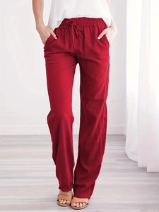 Detail of red cotton linen wide-leg pants with elastic drawstring waistband and textured fabric