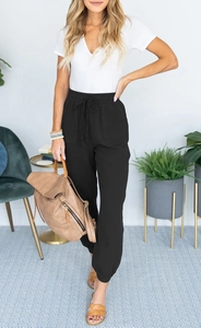 Detail of high-waist black joggers with drawstring waist and textured cotton-linen fabric