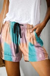 Detail of high waist tie-dye summer shorts featuring drawstring waist and side pockets