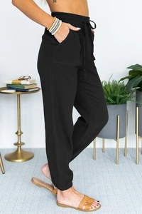 Detail view of high waisted black joggers with drawstring waist and textured fabric