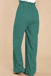 Detailed close-up of high-waisted paperbag waist design on green cotton linen trousers