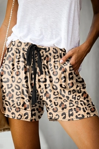 Detail of high waisted leopard print shorts featuring elastic waist and black drawstring