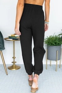 Rear view of black high waist joggers showing crepe texture and elastic cuffs