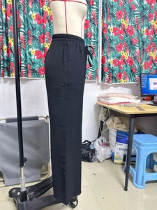 Dettaglio di pantaloni larghi neri casual con vita elasticizzata e coulisse regolabile