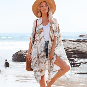 Détail du motif bohème sur un cardigan de plage d'été en mousseline blanche léger