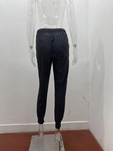 Detail view of high-waist leopard print joggers with elastic waistband and cuffed ankles