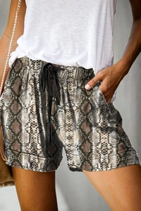 Close-up of snakeskin print high-waisted shorts with black drawstring and folded hem