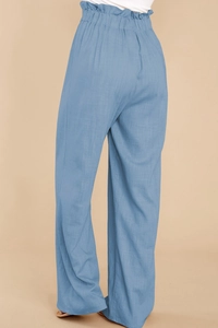 Detail of blue high-waisted paperbag trousers featuring soft pleated elastic cotton linen fabric
