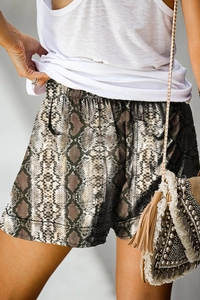 Detail of high waisted snake print shorts featuring elastic waistband and side pockets