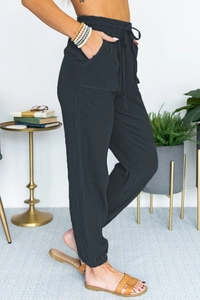 Side view of charcoal grey high-waisted joggers with drawstring and pleated texture