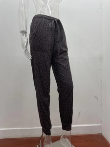 Detailed view of elastic waistband with drawstring and leopard print pattern on jogger pants