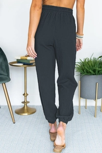 Rear view of dark grey high waisted joggers with textured fabric and elastic cuffs