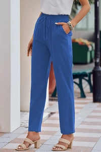 Detail of blue cotton linen pants featuring an elastic drawstring waist and side pockets