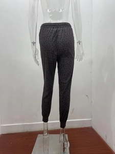 Detail view of elastic waist and cuffed hem on dark grey leopard print joggers