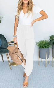 Detail of high waisted white drawstring joggers with side pockets and elastic ankle cuffs