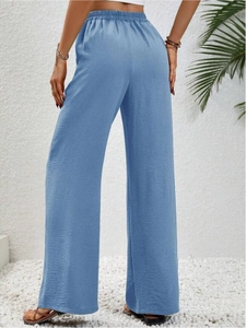 Dettaglio del tessuto dei pantaloni larghi celeste con vita alta elasticizzata