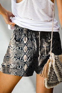 Detail of high waisted snake print shorts featuring two back pockets and elastic waistband