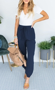 Detail showing the elastic drawstring waistband and fabric texture of navy joggers