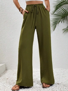 Dettaglio dei pantaloni a gamba larga verde militare con coulisse e tessuto strutturato