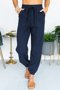 Detail view of navy blue high-waisted jogger pants with drawstring waist and textured fabric