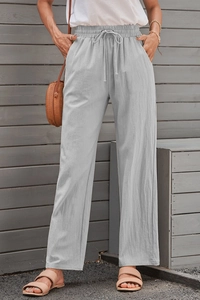 Close-up of light gray cotton linen pants with drawstring elastic waist and pockets