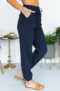 Detail showing high-waisted drawstring design and textured fabric of navy joggers