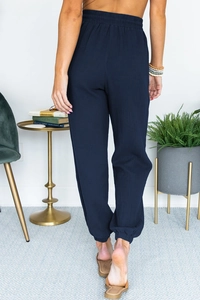 Back view of navy blue high-waisted jogger pants with elastic cuffs and woven texture