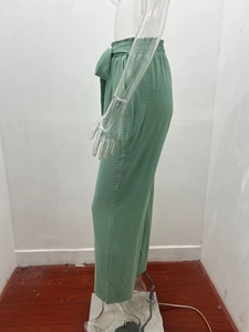 Dettaglio dei pantaloni larghi verde chiaro con vita alta elastica e cintura in tessuto