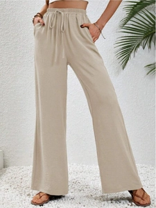 Dettaglio pantaloni beige a vita alta con elastico in vita e coulisse regolabile