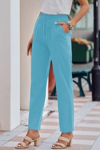 Detail of light blue linen trousers showing the adjustable drawstring waist and side pockets