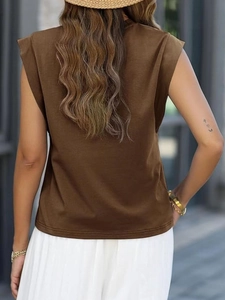 Detailed back view of a dark brown sleeveless crew neck knit top on a model in sunlight