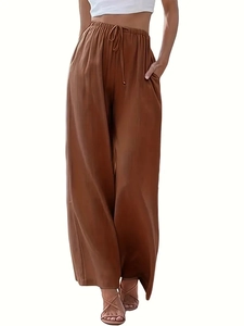Dettaglio dei pantaloni larghi marroni in lino con vita elastica e coulisse e tasche