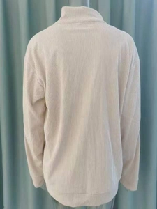 Back view of beige corduroy long sleeve top featuring vertical ribbed texture and stand collar
