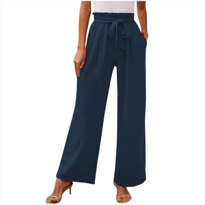 Dettaglio dei pantaloni a gamba larga blu navy a vita alta con cintura a fiocco