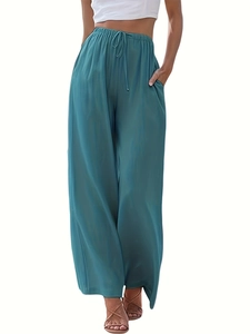 Dettaglio dei pantaloni in lino a vita alta con coulisse e pratiche tasche laterali
