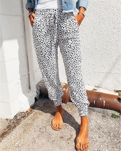 Detail of leopard print joggers with drawstring waist and elastic cuffs on a model