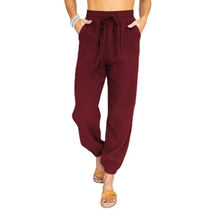 Detail view of burgundy high-waisted joggers with drawstring and textured fabric