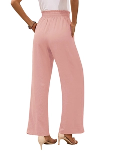 Dettaglio dei pantaloni larghi a vita alta con fascia elastica pieghettata rosa chiaro