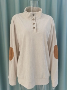 Detailansicht des Cord-Pullovers mit geknöpftem Stehkragen und braunen Ellbogen-Patches