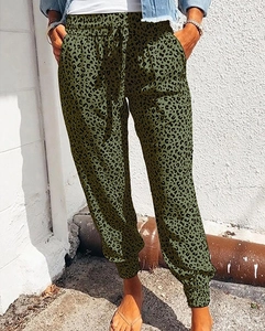 Close-up of military green leopard print trousers featuring drawstring waist and side pockets