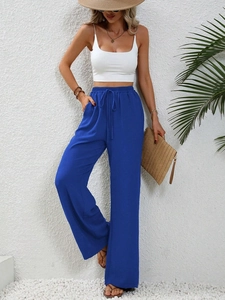 Dettaglio dei pantaloni a gamba larga a vita alta con coulisse in tessuto blu testurizzato