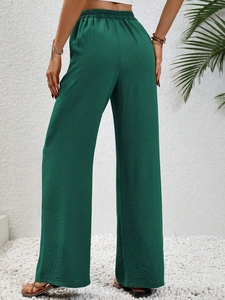 Dettaglio dei pantaloni a gamba larga a vita alta verde scuro con tessuto elasticizzato