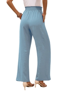 Dettaglio dei pantaloni a gamba larga azzurri a vita alta con elastico e tasche laterali