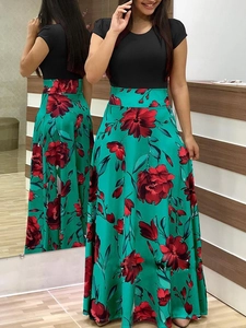 Détail de robe longue évasée à taille haute avec haut noir et jupe à fleurs vert