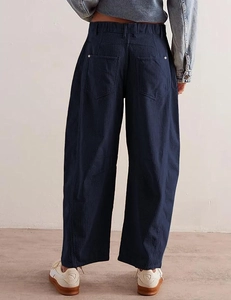 Detail view of high-waist corduroy pants with elastic waistband and back patch pockets
