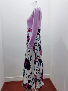 Détail d'une robe ajustée à manches longues avec haut violet et jupe longue fleurie