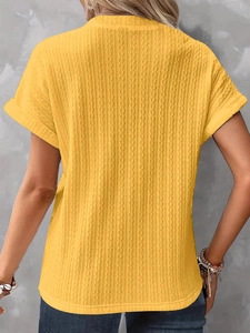 Dettaglio del top giallo in maglia a nido d'ape con motivo a trecce verticali testurizzato